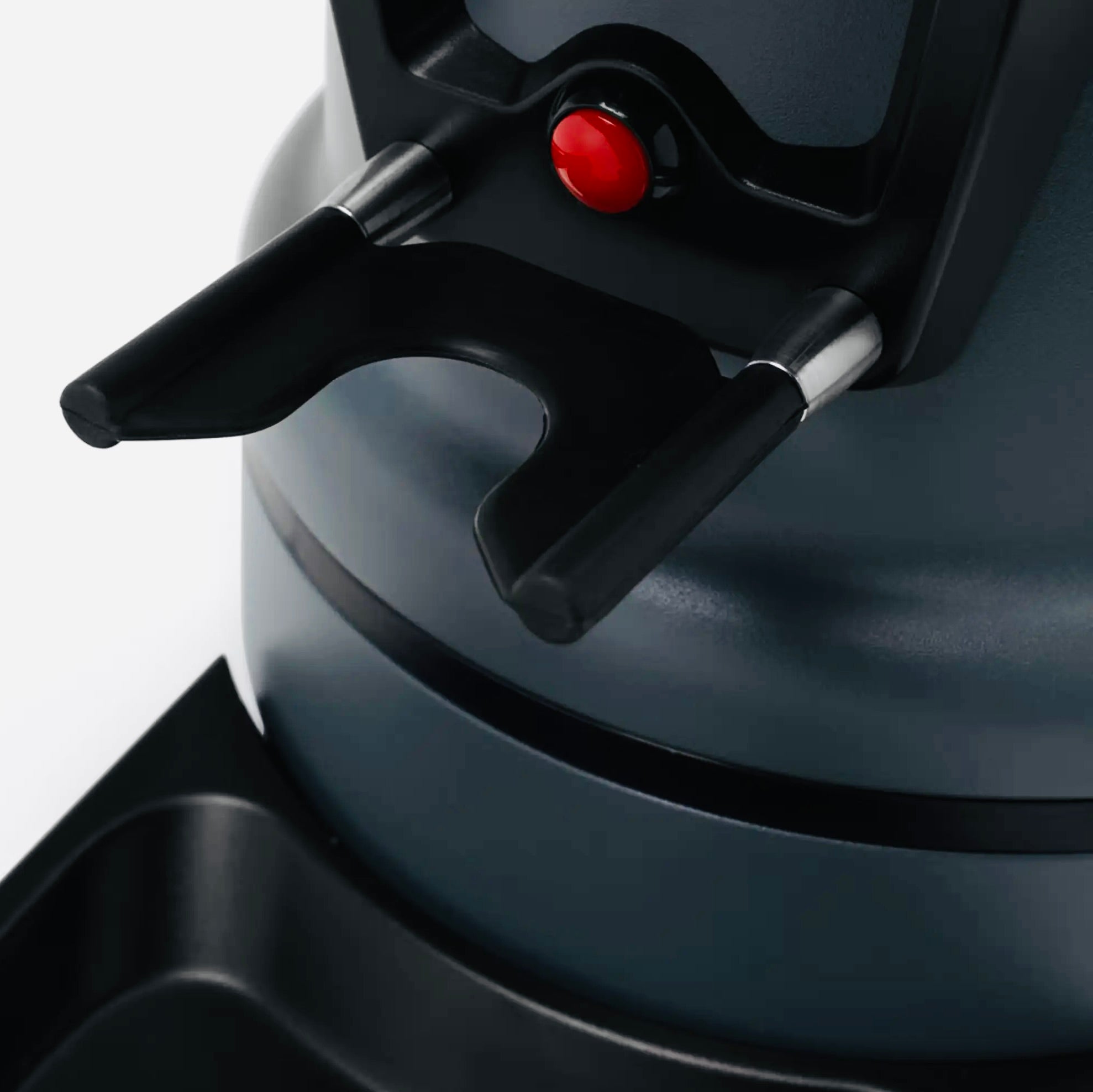 Close-up of a black Macap grinder activation button